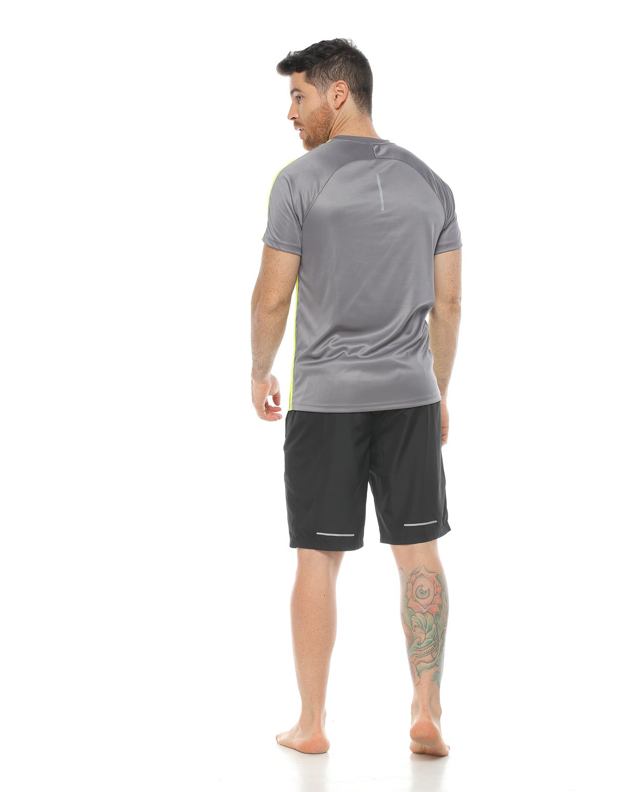 modelo con camiseta deportiva color gris y pantaloneta deportiva color negro para hombre cuerpo completo parte trasera