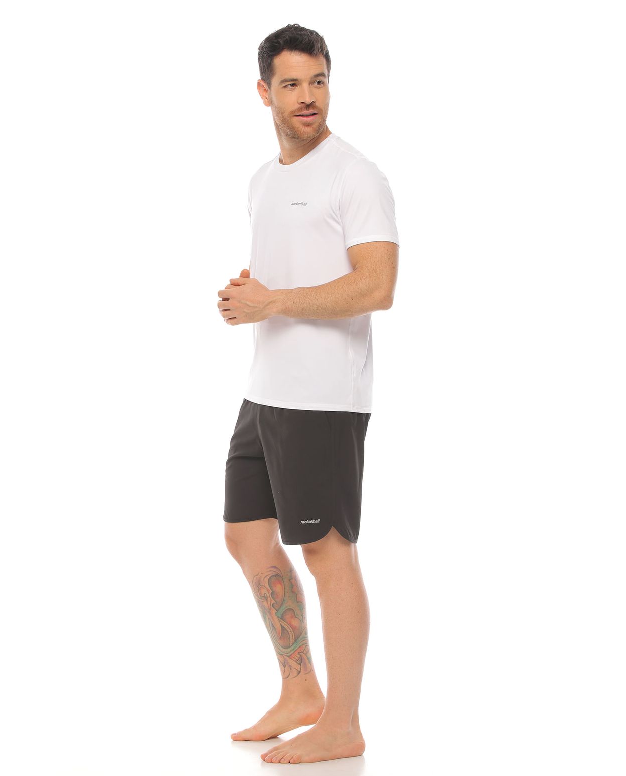 modelo con pantaloneta deportiva color negro y camiseta deportiva color blanco cuerpo completo parte lateral derecha