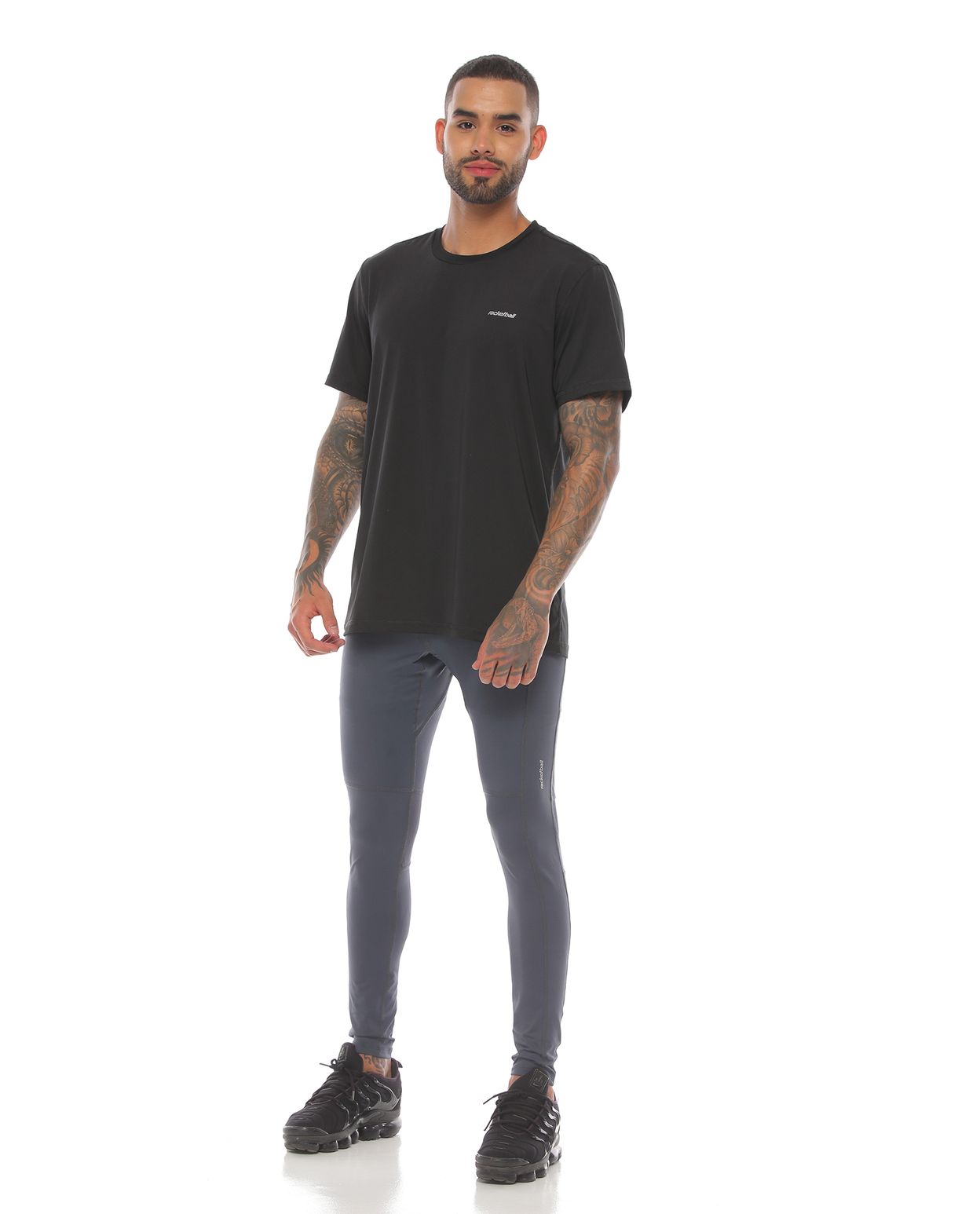 modelo con licra deportiva color gris oscuro y camiseta deportiva color negro para hombre cuerpo completo