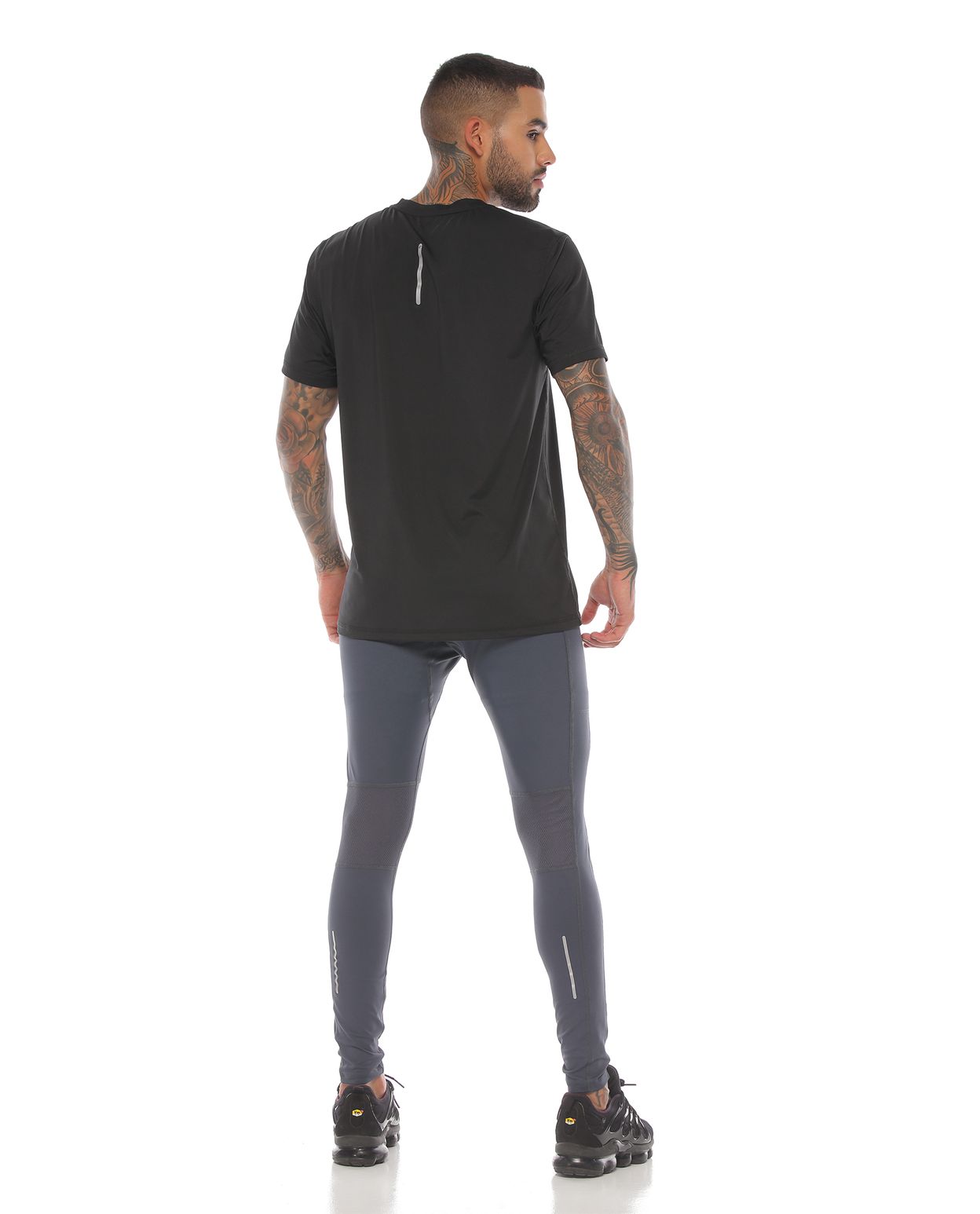 modelo con licra deportiva color gris oscuro y camiseta deportiva color negro para hombre cuerpo completo parte trasera