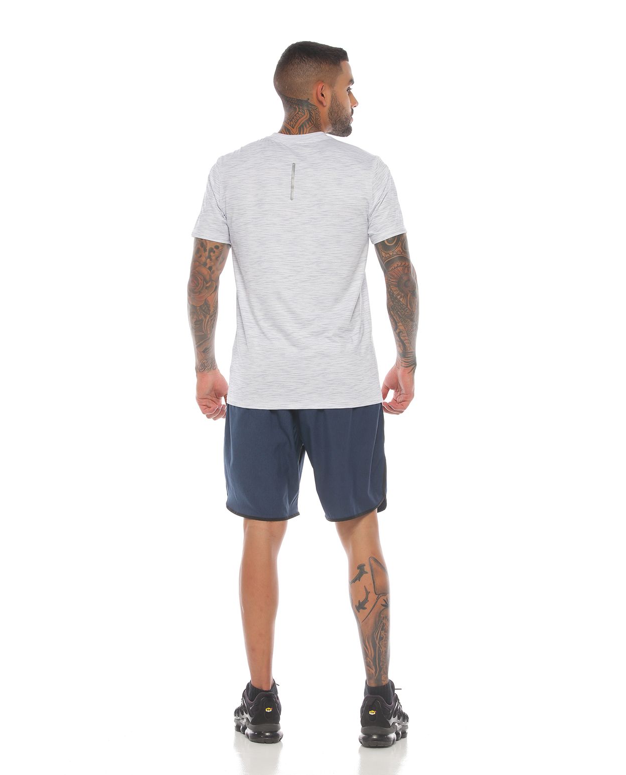 modelo con pantaloneta deportiva color petroleo negro y camiseta manga corta deportiva color blanca para hombre cuerpo completo parte trasera