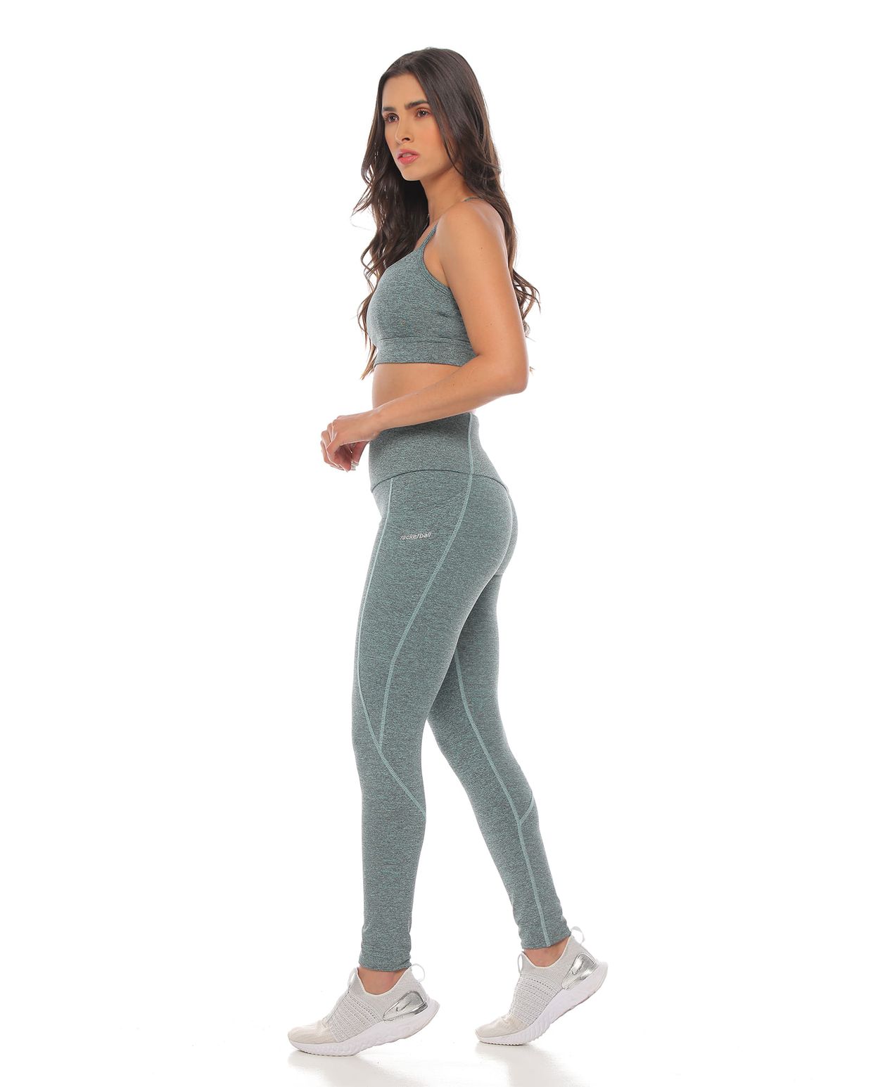 modelo con top deportivo color menta jaspe y licra deportiva para mujer cuerpo completo parte lateral izquierda