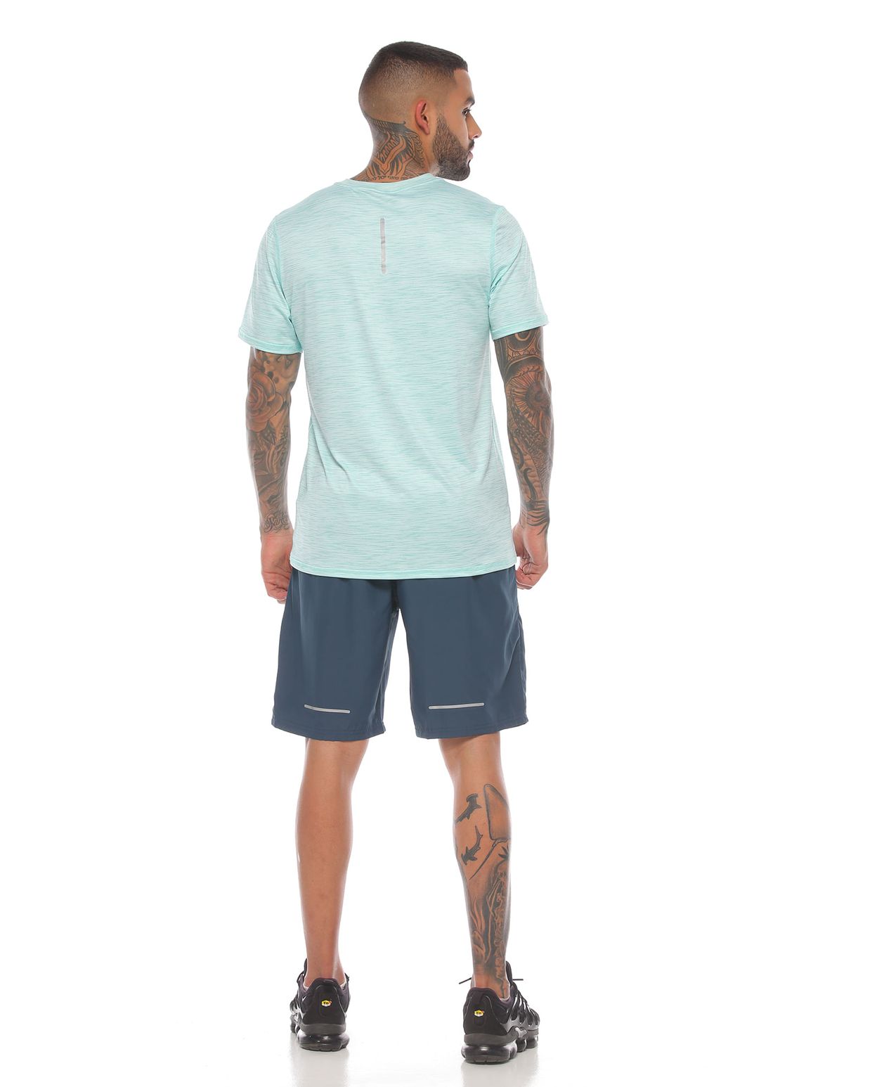 modelo con pantaloneta deportiva color petroleo y camiseta deportiva color verde para hombre cuerpo completo parte trasera