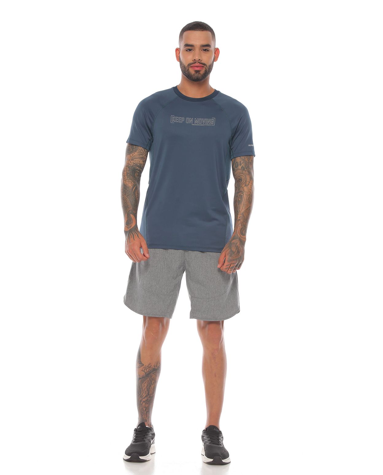 modelo con camiseta deportiva color azul petroleo y pantaloneta gris para hombre cuerpo completo parte frontal