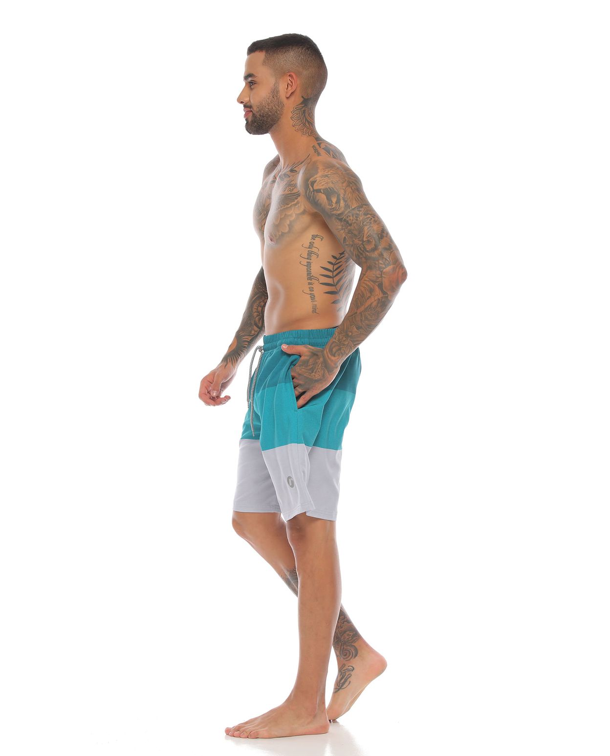 modelo con pantaloneta de playa larga color jade para hombre cuerpo completo parte lateral derecha