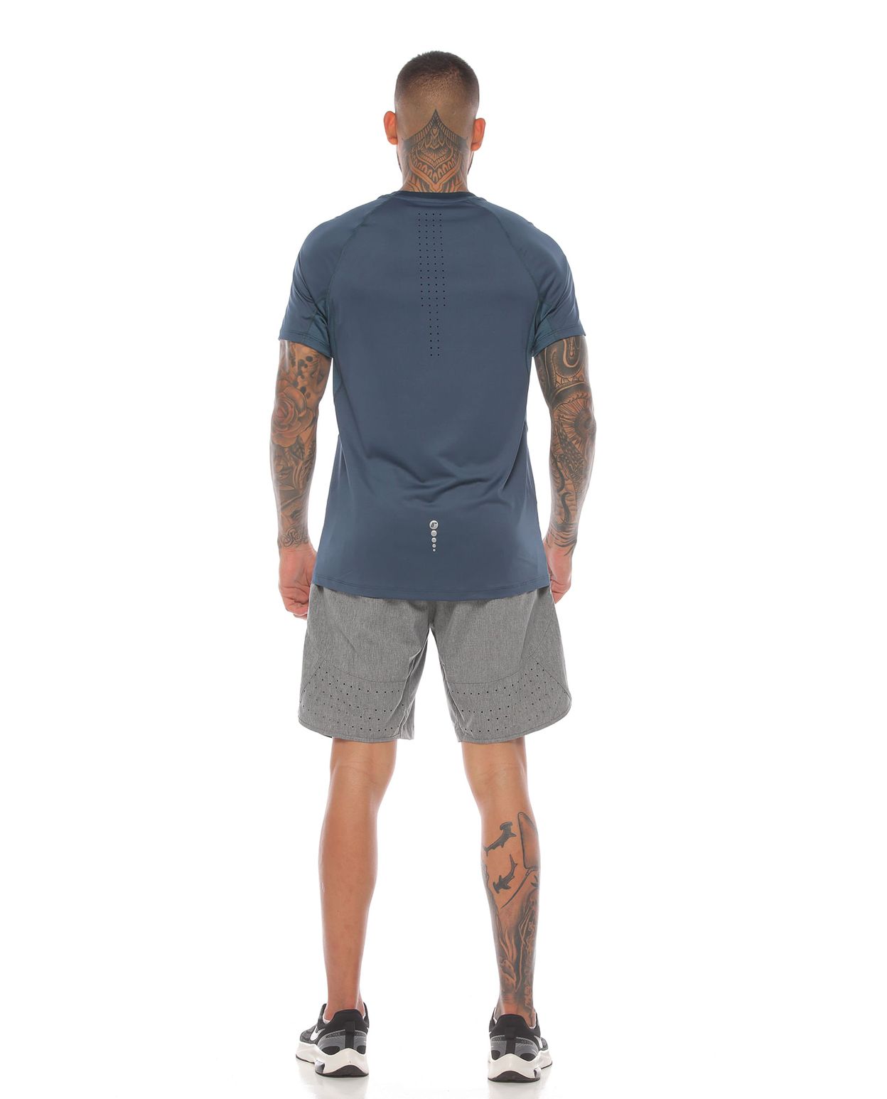 modelo con camiseta deportiva color azul petroleo y pantaloneta gris para hombre cuerpo completo parte trasera