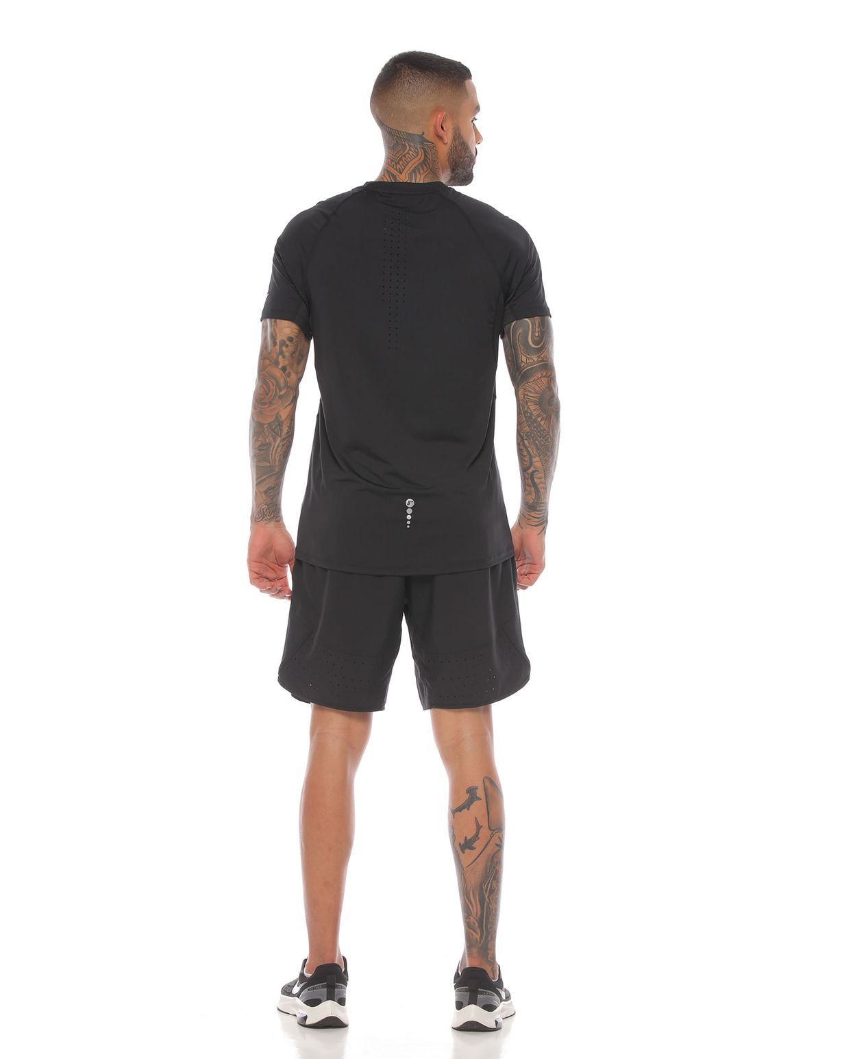 modelo con camiseta manga corta y pantaloneta deportiva color negro para hombre cuerpo completo parte trasera