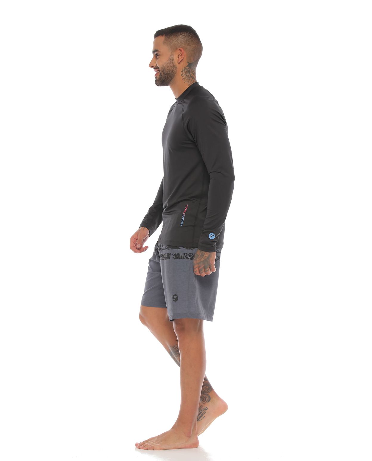 modelo con pantaloneta de playa larga y camibuso con proteccion uv color negro para hombre cuerpo completo parte lateral derecha