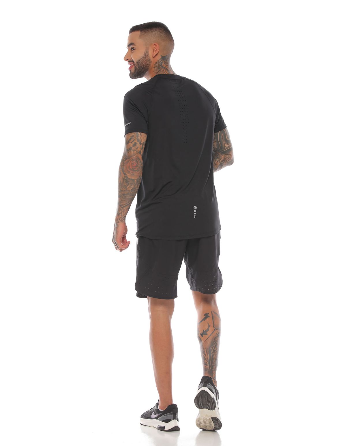 modelo con pantaloneta y camiseta manga corta deportiva color negro para hombre cuerpo completo parte trasera