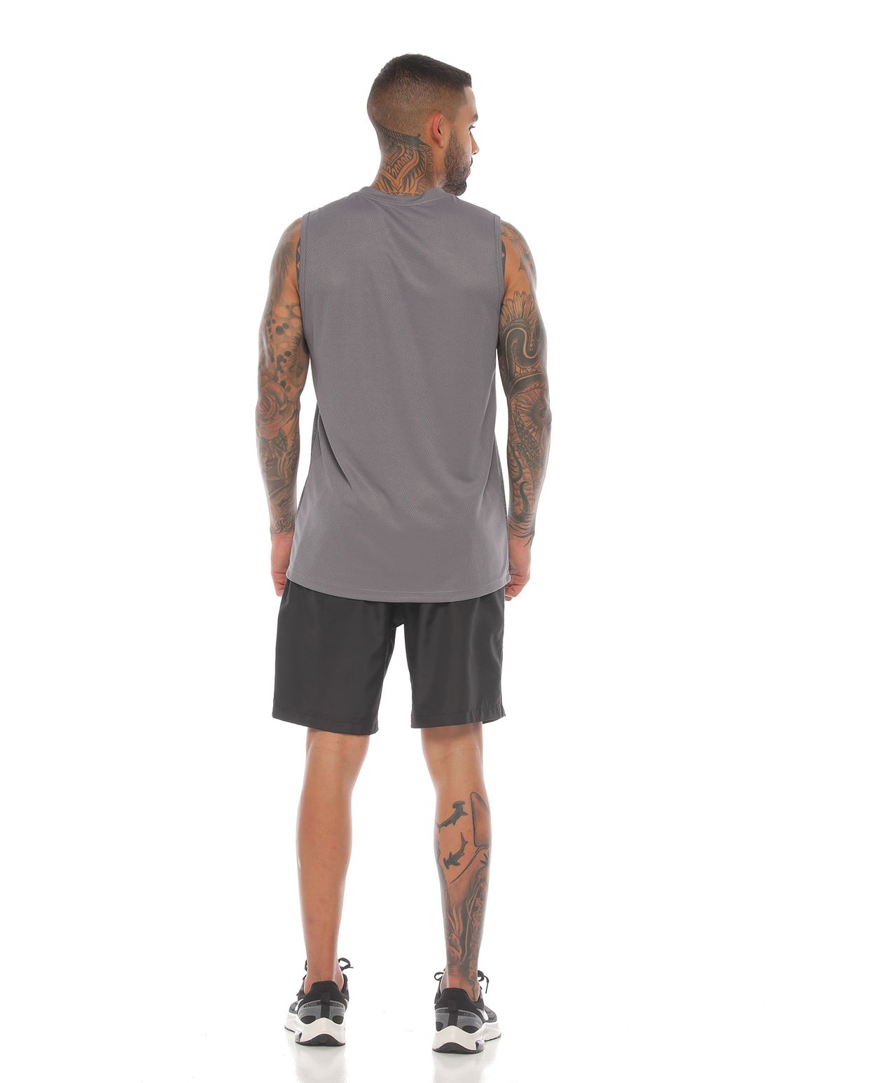 modelo con esqueleto deportivo hombre color gris claro y pantaloneta color negro cuerpo completo parte trasera