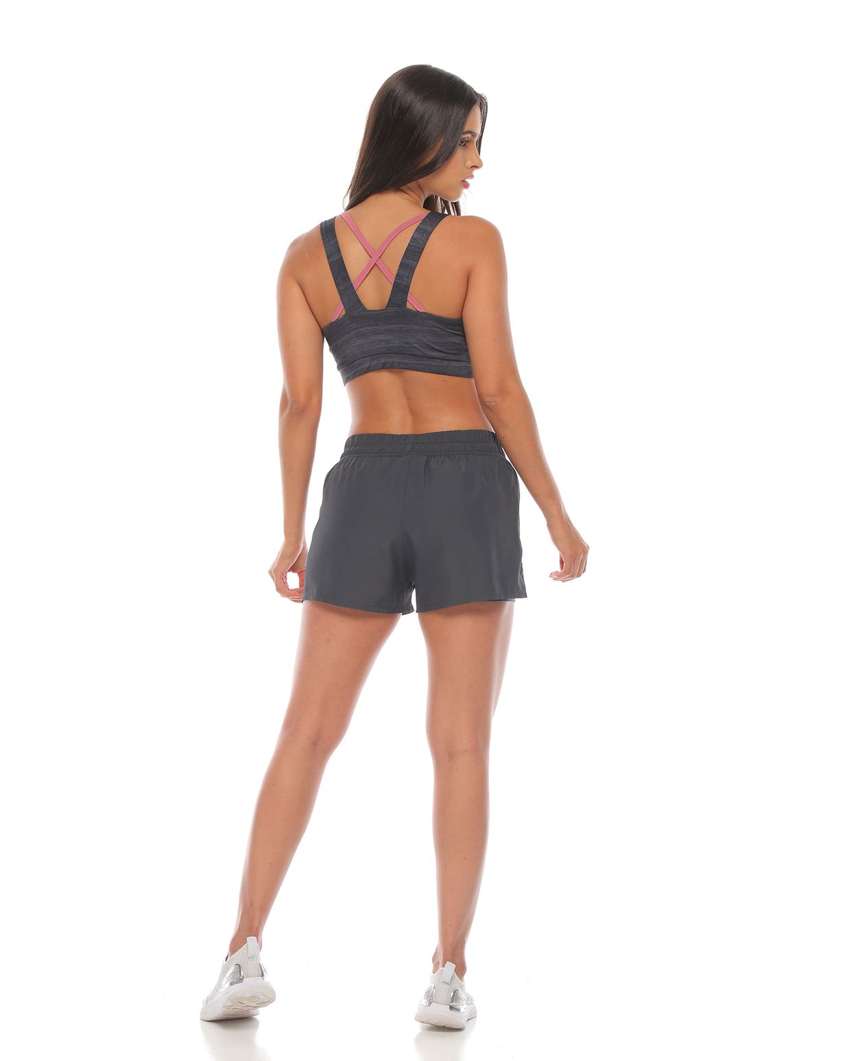 modelo con pantaloneta running deportiva color gris con fit interior y top deportivo gris para mujer parte trasera