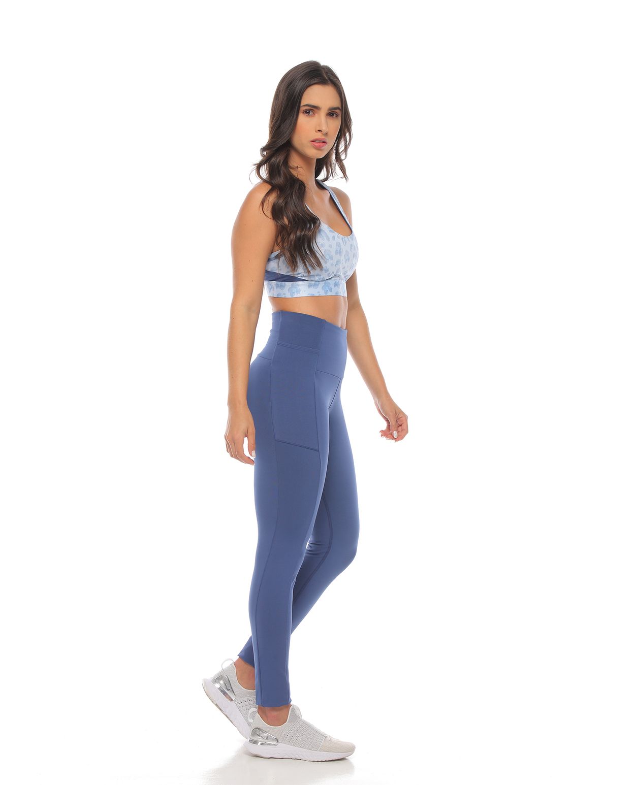 modelo con top deportivo soporte medio color azul hortensia y licra deportiva color azul para mujer cuerpo completo parte lateral derecha