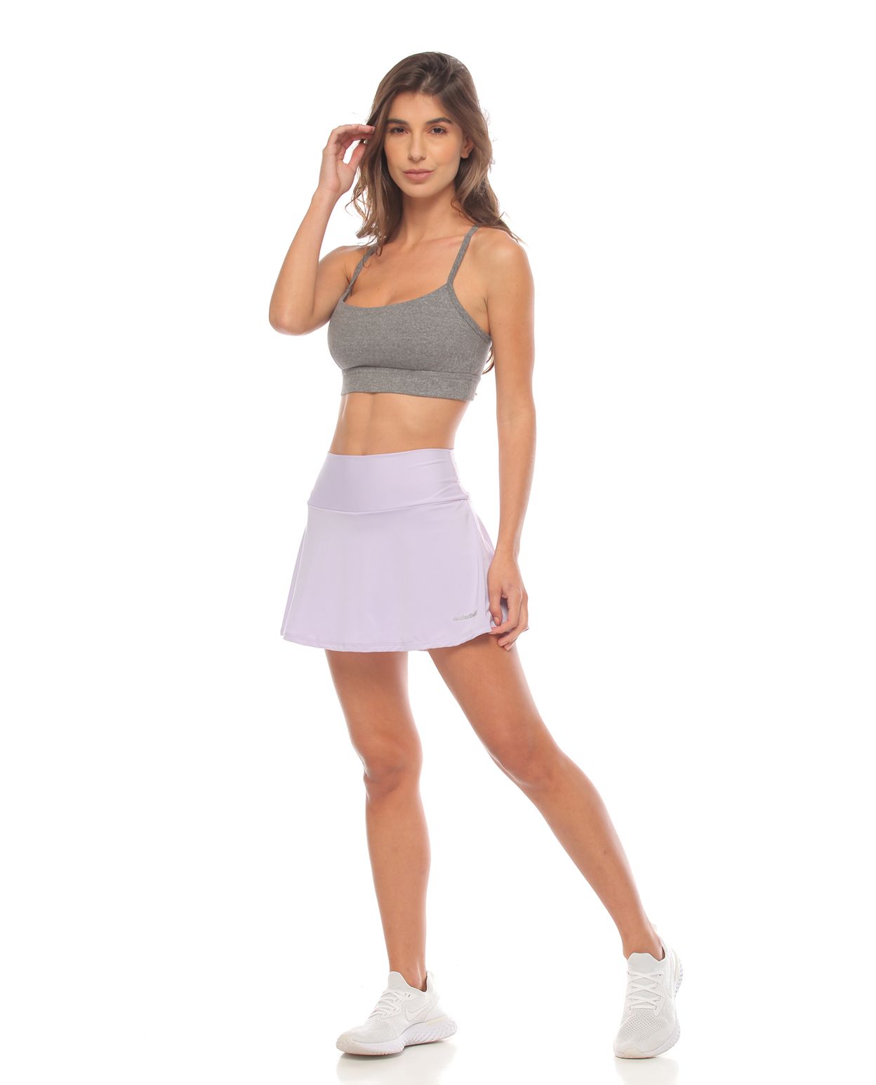 modelo con falda deportiva color lila y top deportivo gris para mujer cuerpo completo