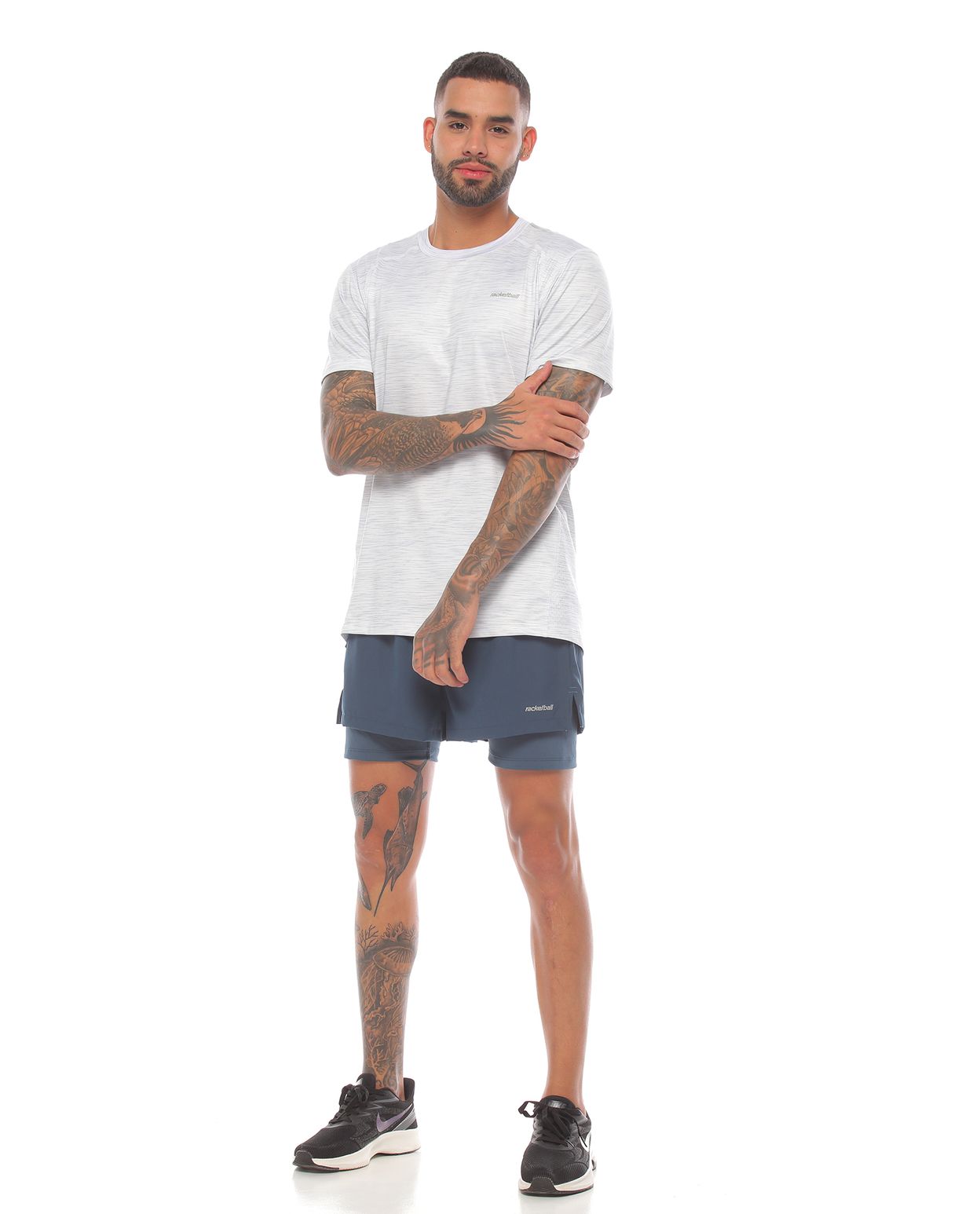 modelo con pantaloneta deportiva color petróleo y camiseta deportiva manga corta blanca para hombre cuerpo completo