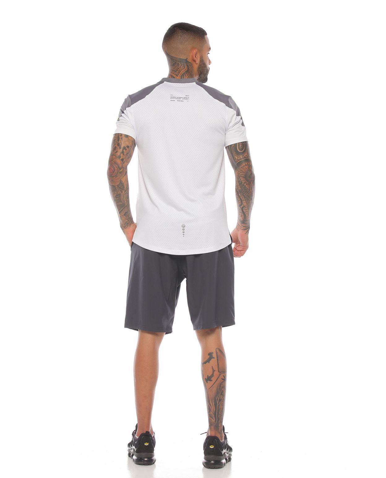 modelo con pantaloneta deportiva color gris y camiseta deportiva manga corta blanca para hombre parte trasera