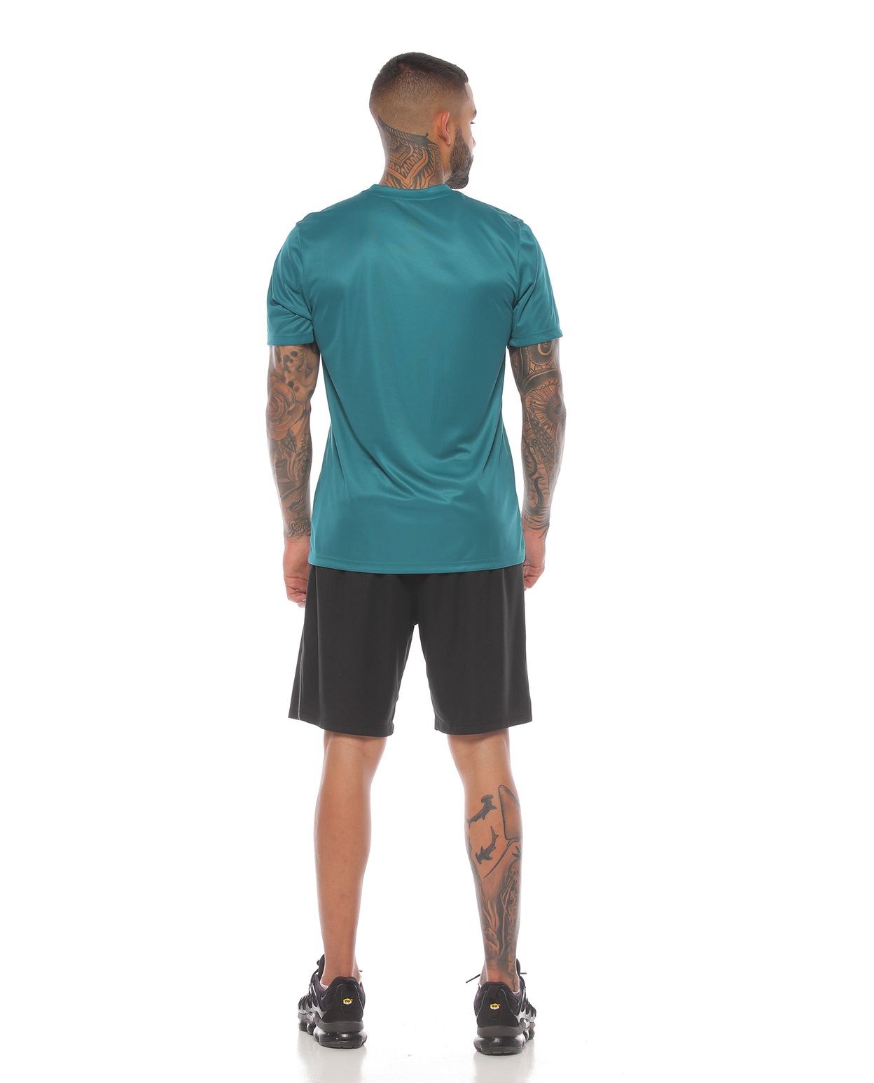 modelo con camiseta deportiva manga corta color verde y pantaloneta deportiva negra para hombre parte trasera